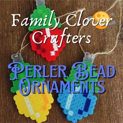 A wooden background features three holiday light style ornaments made out of perler beads; one each or red, yellow, and blue. Script text reads "Family Clover Crafters: Perler Bead Ornaments"