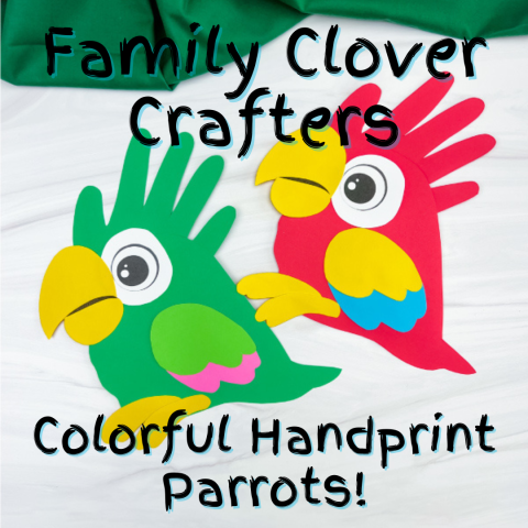 Two craft parrots are arranged on a table. Their frill is made with a child's handprint, the fingers creating the look of feathers. The parrots are bright green and bright red, with yellow beaks and feet. Messy text reads, "Family Clover Crafters: Colorful Handprint Parrots!"