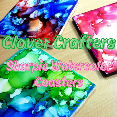 Three coasters are arranged on a brown tabletop. The three coasters have watercolor patterns on them in different color palettes. Green text reads, "Clover Crafters." Pink text reads, "Sharpie Watercolor Coasters." 