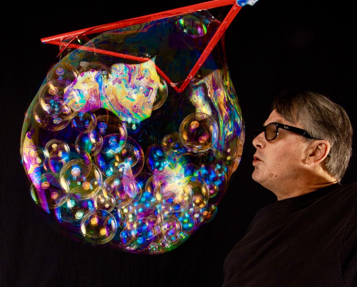 Man blowing on an enormous bubble